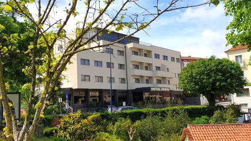 a large white building on a city street at Hotel Eden in Luso