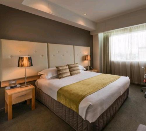 - une chambre avec un grand lit et une fenêtre dans l'établissement Hotel Artist, à Tirana