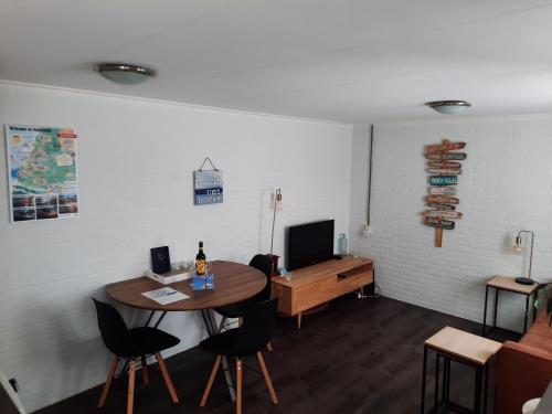 a room with a table and chairs and a television at Have a nice stay! - Blue Beach House 350 meters from sea in Noordwijk aan Zee