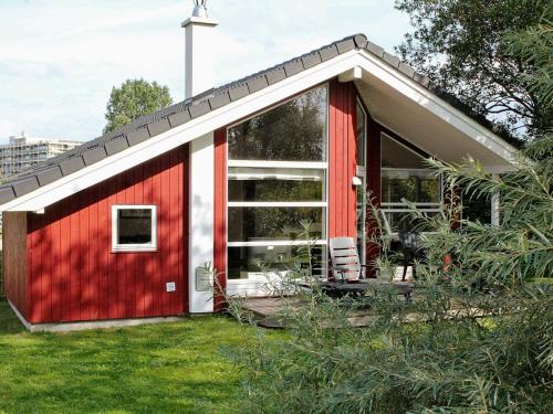 a red and white house with a garden at 8 person holiday home in Gro enbrode in Großenbrode