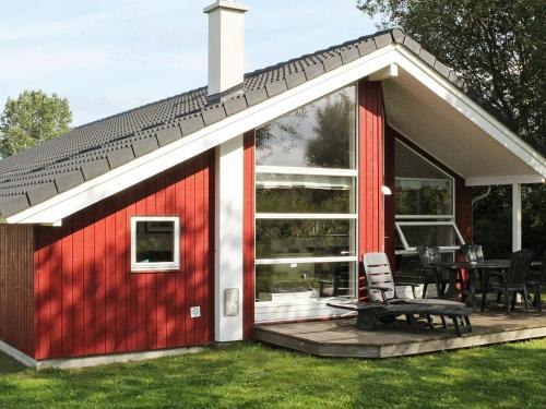 a red and white cottage with a patio at 8 person holiday home in Gro enbrode in Großenbrode