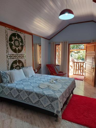 a bedroom with a bed and a red rug at Sitio Recanto Suave in Domingos Martins