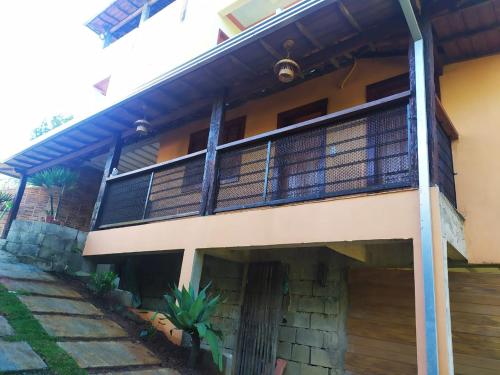 a house with a balcony on the side of it at Suites Cantinho de MInas in Lavras Novas