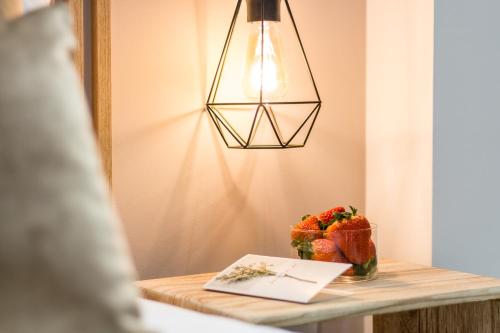 a table with a bowl of strawberries and a lamp at Linda Boutique Hotel in Marbella