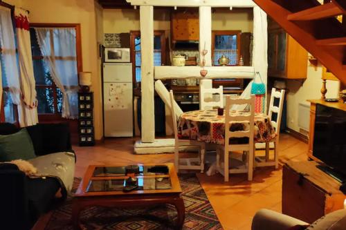 un salon avec une table et une cuisine dans l'établissement Gîte Les Cerisiers, à Triembach-au-Val