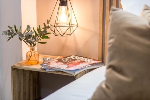 a table with a lamp and a book and a vase at Linda Boutique Hotel in Marbella