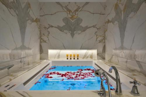 a tub filled with red confetti in a bathroom at Hotel Splendide Royal - The Leading Hotels of the World in Rome