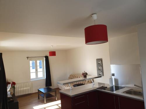 d'une cuisine avec évier et lumière rouge. dans l'établissement Appartement en plein centre de Deauville 2éme, à Deauville