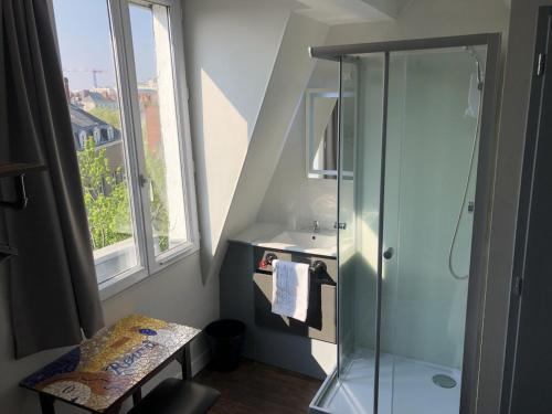 baño con ducha, lavabo y ventana en Hôtel Renova, en Nantes