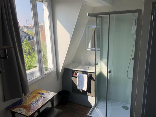 une salle de bain avec une douche et un lavabo et une fenêtre dans l'établissement Hôtel Renova, à Nantes