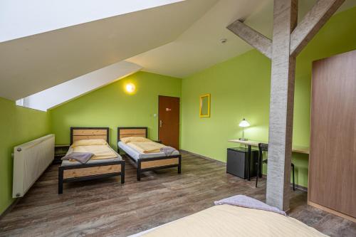 2 camas en una habitación con paredes verdes en Inter Hostel Liberec, en Liberec