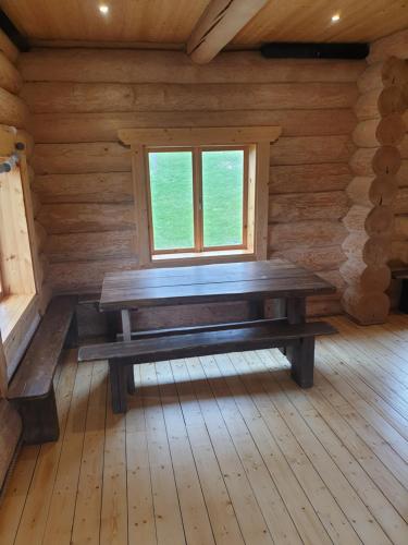 eine Holzbank in einem Zimmer mit Fenster in der Unterkunft Lebola Puhkemaja in Kasaritsa