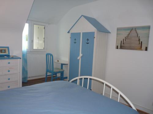 una camera con letto, tavolo e sedia di Maison Terre et Mer a Poullan-sur-Mer