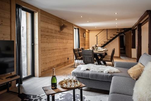 ein Wohnzimmer mit einem Sofa und einem Tisch in der Unterkunft Nouveau et spacieux, Place de l'Eglise et terrasse privative in La Clusaz