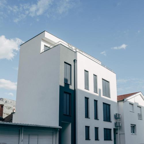 un edificio bianco con finestre nere in cima a un edificio di Villa Hodžić a Mostar