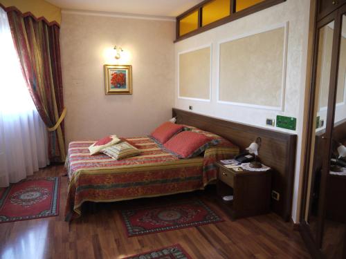a small bedroom with a bed and a table at Hotel La Ruota in Pianfei