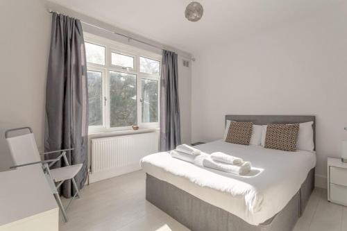 a bedroom with a bed with two towels on it at Modern 2 Bedroom Apartment in Morden in London