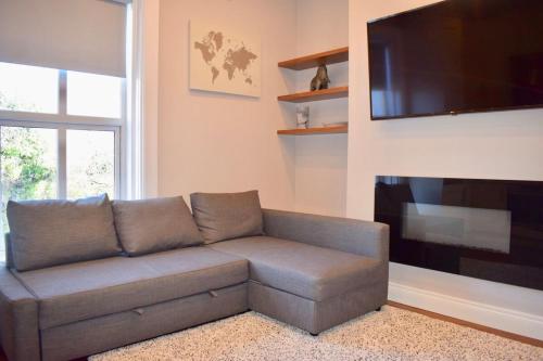 a living room with a couch and a flat screen tv at Beautiful 2 Bedroom Ballsbridge Apartment near the Aviva in Dublin