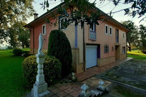 a house with a statue in front of it at El Camín Real in Rañeces