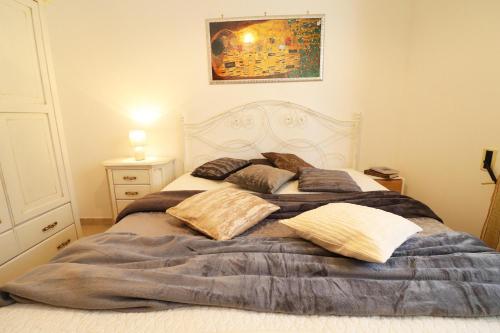 un letto con cuscini sopra in una camera da letto di Casa Caterina a Otranto a Otranto