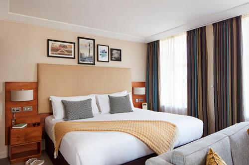 a hotel room with a bed and a couch at The Clermont London, Charing Cross in London
