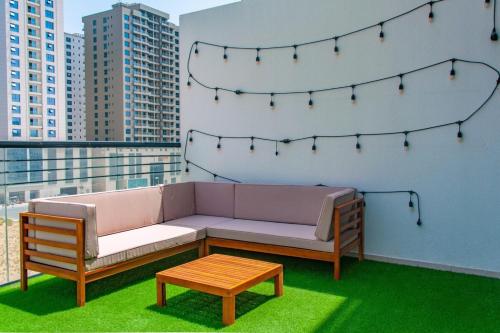 a couch and a coffee table on a balcony at Sophisticated 2 Bedroom with Lush Interiors in JVC in Dubai