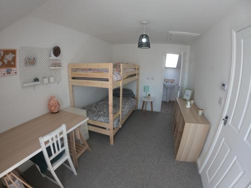 a small room with a bunk bed and a desk at Cosy townhouse near Kidwelly in Kidwelly