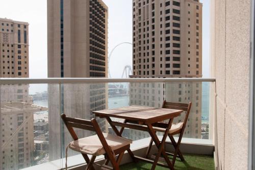 a table and chairs on a balcony with a view of a city at Cozy 1 Bedroom with Dubai Eye and sea views minutes to beach in Dubai