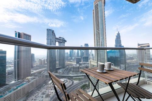 a balcony with a table and chairs and a view of the city at Luxurious 1 Bedroom Downtown in Dubai