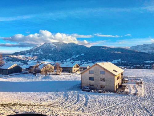 a house in the snow with mountains in the background at Rosenhaus 2 in Schwarzenberg im Bregenzerwald