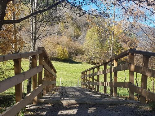 a wooden bridge over a field with a fence at Hotel Santa Bàrbara De La Vall D'ordino in Ordino