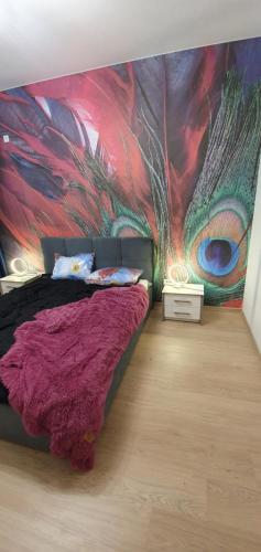 a bedroom with a wall with a peacock mural at Апартаменты на Греческой in Odesa