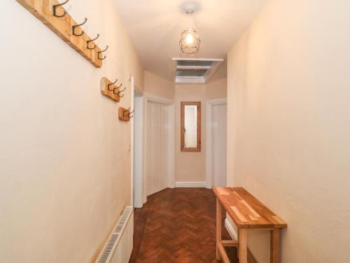 a hallway with a wooden table in a house at Ty Garth in Benllech