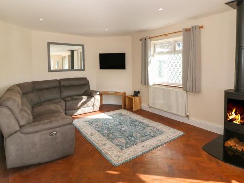 a living room with a couch and a fireplace at Ty Garth in Benllech