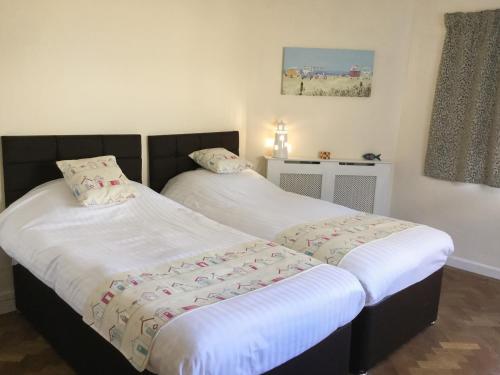 two beds sitting next to each other in a room at Ty Garth in Benllech