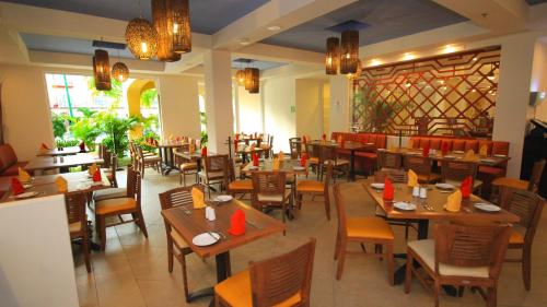 un restaurante con mesas de madera y sillas en una habitación en Holiday Inn Huatulco, an IHG Hotel en Santa Cruz - Huatulco