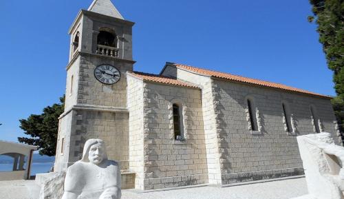 a clock tower with a statue in front of a building at La Vista apartments in Mimice