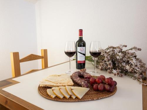 a table with a bottle of wine and cheese and wine glasses at Bed and Breakfast Dorgali in Dorgali