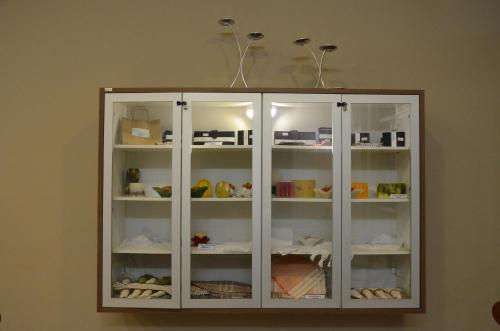 a white cabinet with food items in it at Hotel Lenheiros in São João del Rei