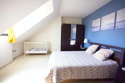 a bedroom with a bed and a blue wall at L'annexe in Fécamp