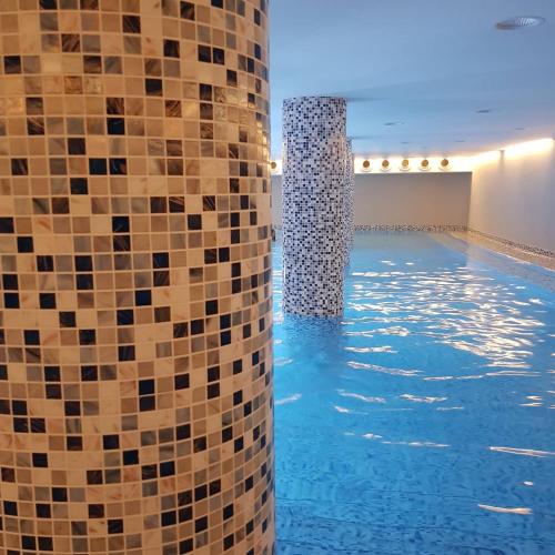 a swimming pool with tiles on the side of it at Apartman Ibarstar in Vrnjačka Banja