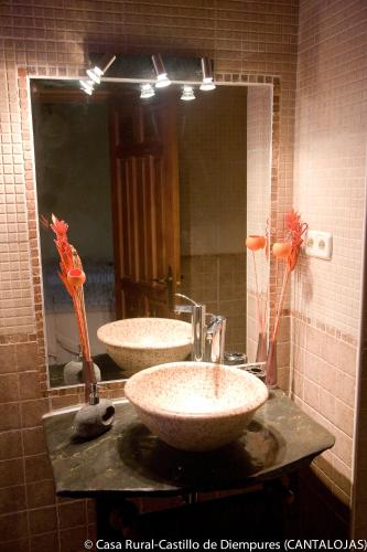 a bathroom with two sinks and a large mirror at Casa Rural Castillo Diempures in Cantalojas