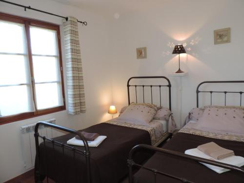 deux lits dans une chambre avec deux fenêtres dans l'établissement Le Faré Tchanqué gite 2 ch piscine parking wifi gratuit, à Cavaillon