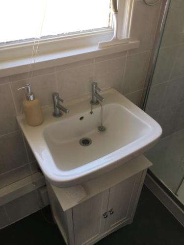 a white sink in a bathroom with a window at Moonlight Ridge in Dartmouth