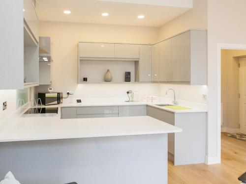 a kitchen with white cabinets and a sink at Pass the Keys - Spacious flat with private Sun Terrace in South East London in London