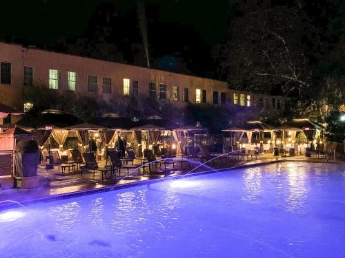 a large swimming pool with tables and chairs at night at Fairmont Sonoma Mission Inn & Spa in Sonoma