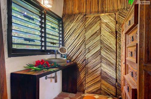 a bathroom with a counter with flowers on it at Beachfront bungalows- Soliman Bay in Tulum