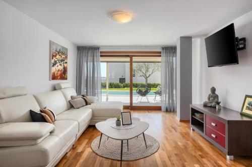 a living room with a white couch and a table at Belvedere Holidays Villas in Novigrad Istria