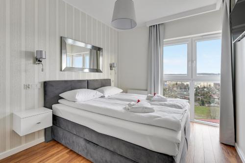 a bedroom with a large bed with a large window at Wave Apartments - Albatros in Gdańsk