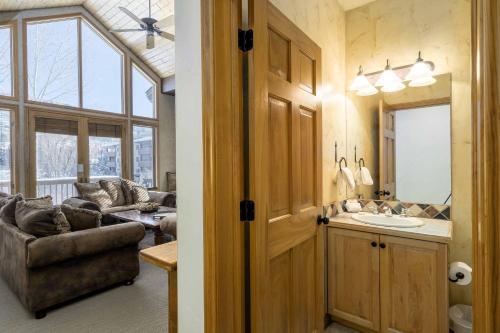 a bathroom with a sink and a living room at Evergreens 04 in Steamboat Springs